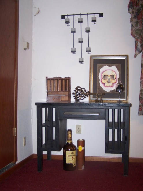 This is a little corner of the dining room. The door leads down to an old basement. This was a hand-me-down metal desk. We fell in love with it. We don't really use it as a desk, but more as a table and storage (the house has NO extra linen-type closets!). The little jar is a bag of HUGs! The paiting is one by my brother, which he gave me for my birthday this year. I love this little area.