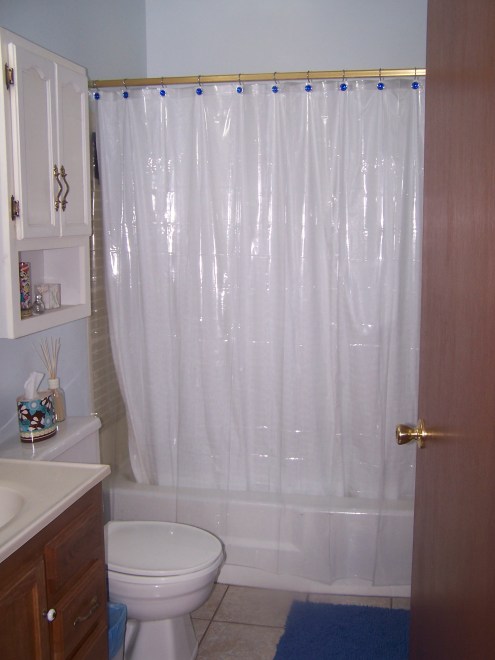 The view from the door into the tiny bathroom. Its small but we managed to fit all of our things in there.  It feels really bright and spa-ish because of the light blue walls and white curtains.  We added a blue rug and blue curtain hooks.