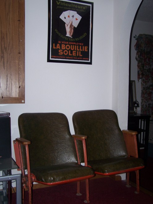 These old movie theater seats were a salvaged find.  They sit next to the TV on the right.  The vintage ad above matches them so well.