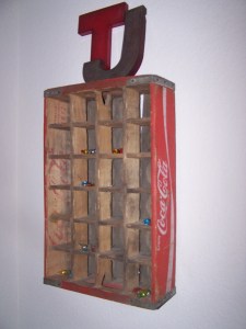 A worn coke crate is hung up in our bedroom.  