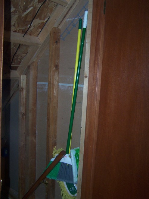 The brooms and mops hanging so nicely just inside our basement door.  